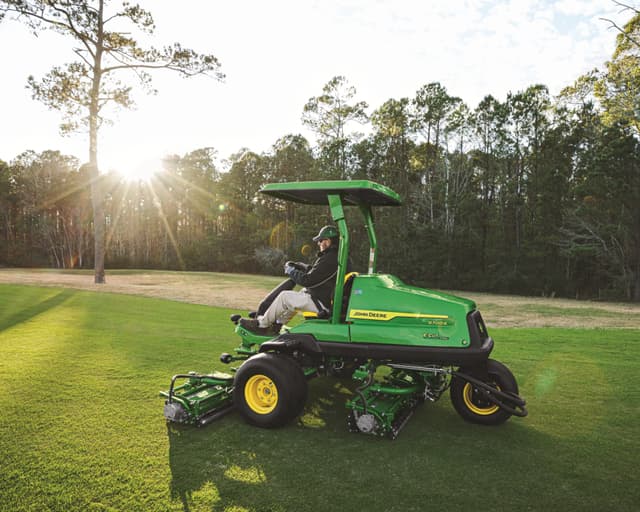 A worker maintains a golf course in California with a John Deere mower.