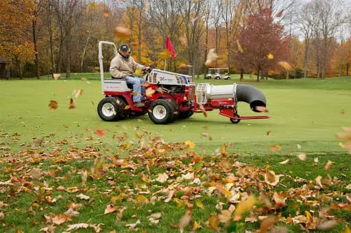 A Ventrac Mower with a leaf blower attachment maintains a property.