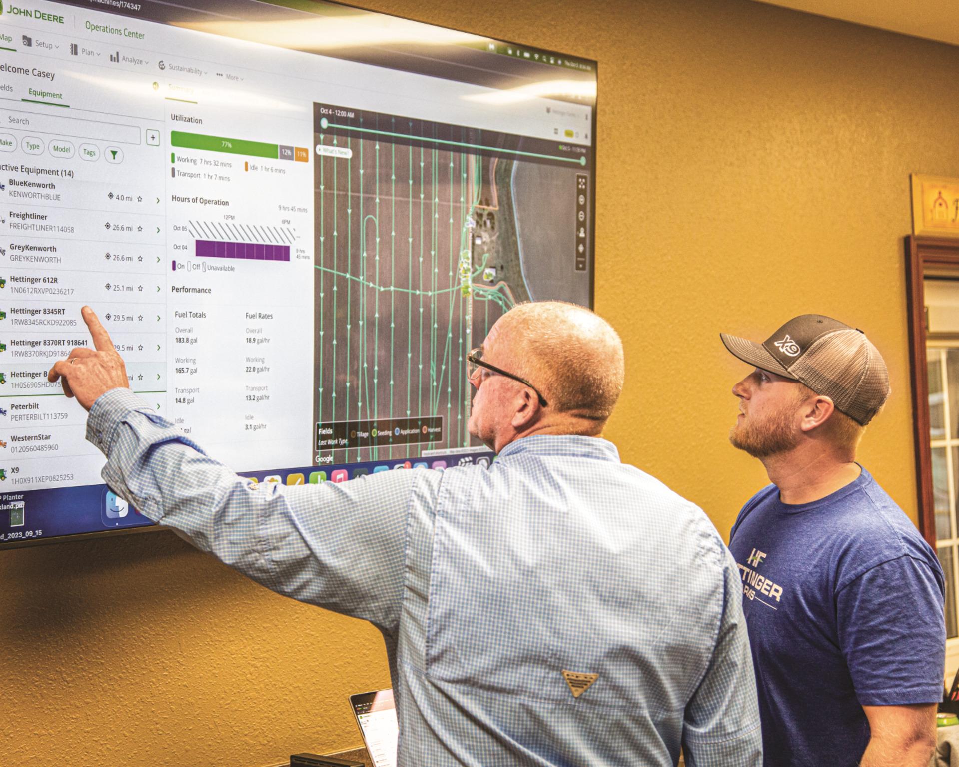 Workers look at information on the John Deere Operations Center.