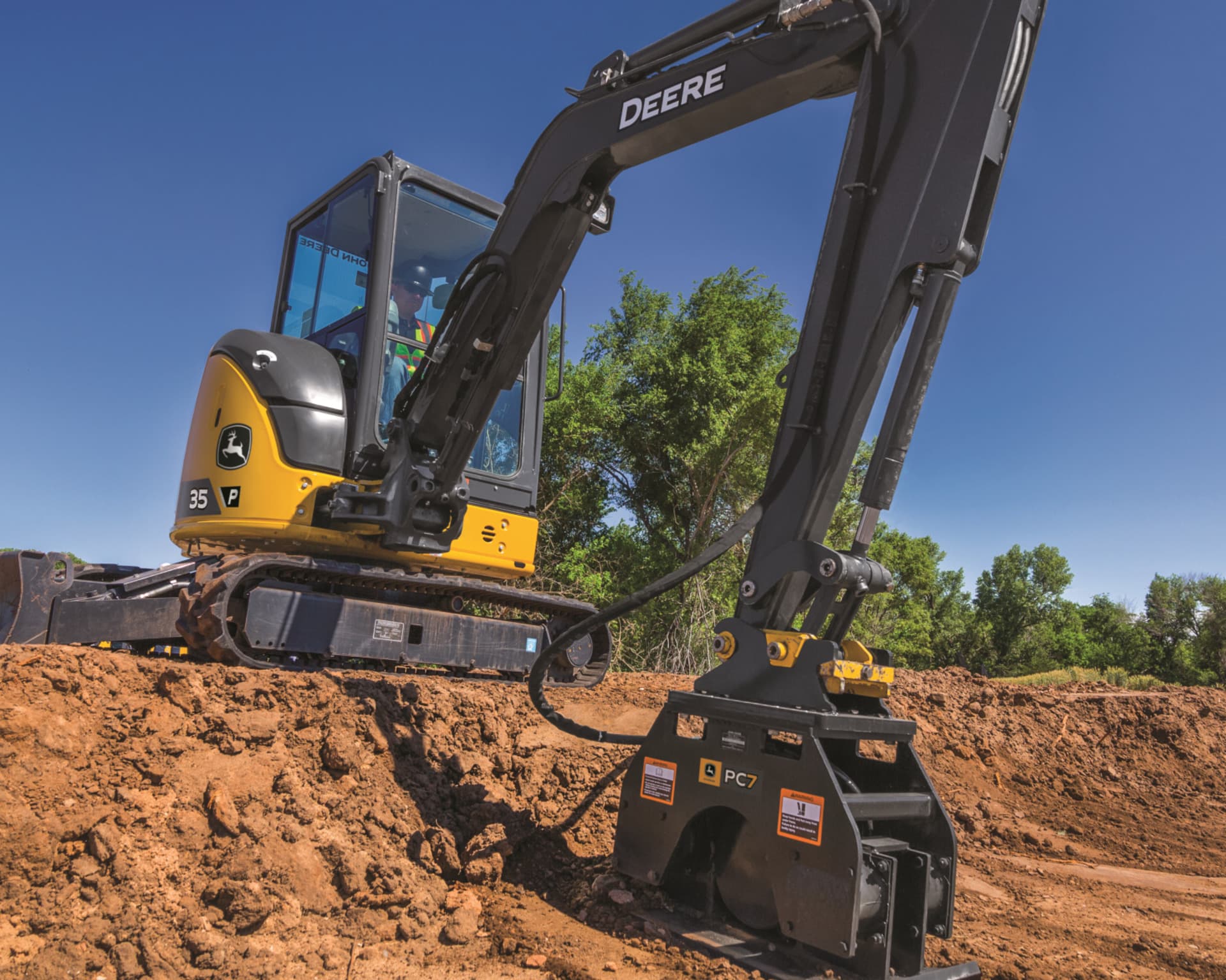 A John Deere 35G Compact Excavator digs a hole for a pool.
