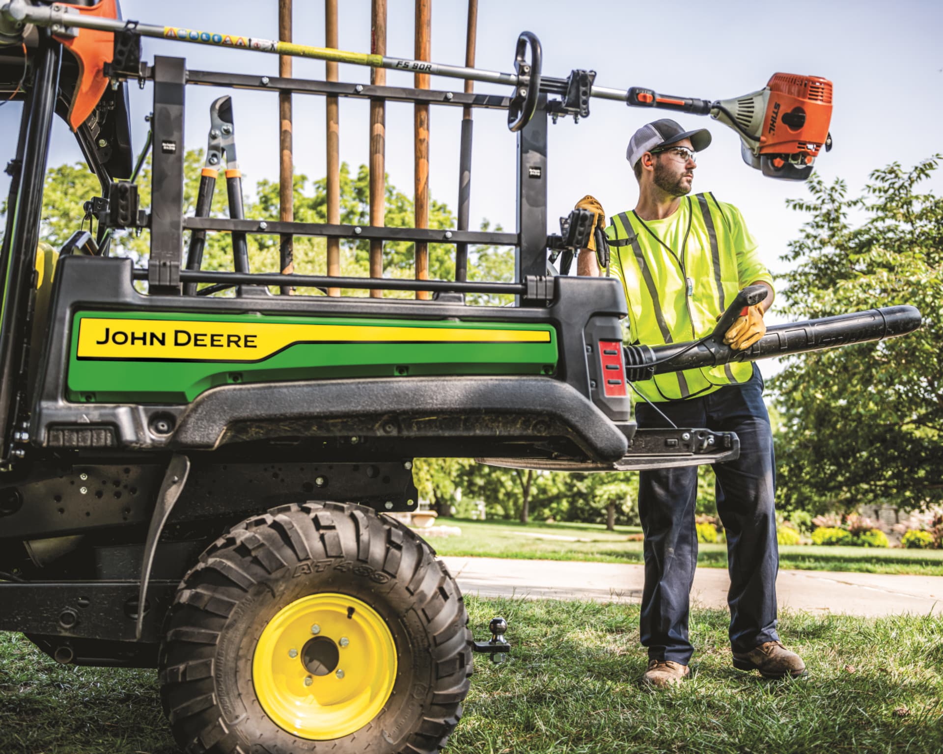 A worker uses a John Deere Gator XUV to help with landscaping work.