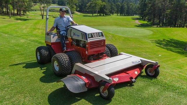 A workers operates a Ventrac mower with a front mower deck on a golf course in California.