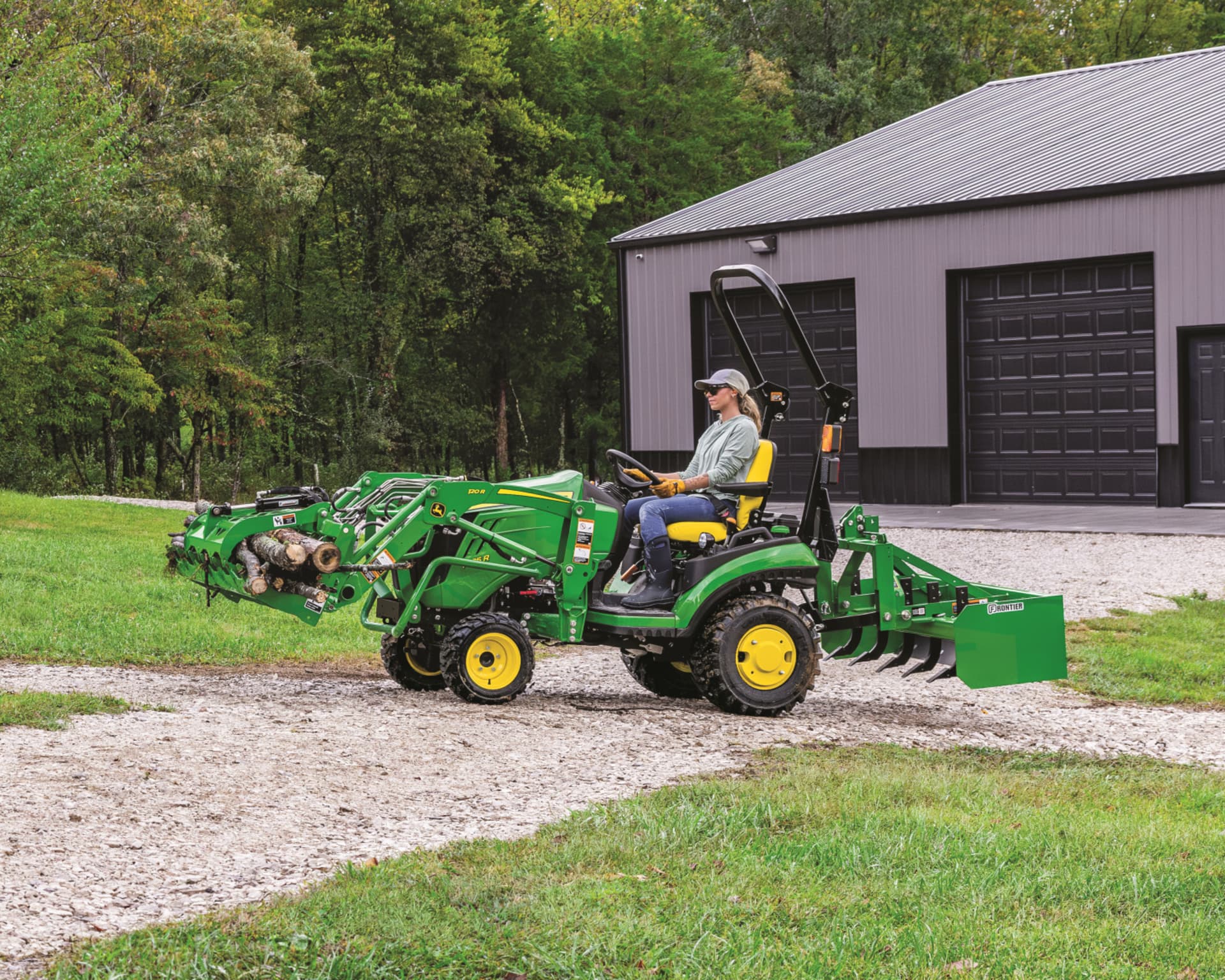 A homeowner with a John Deere 1025R transports logs using a front-end loader attachment.