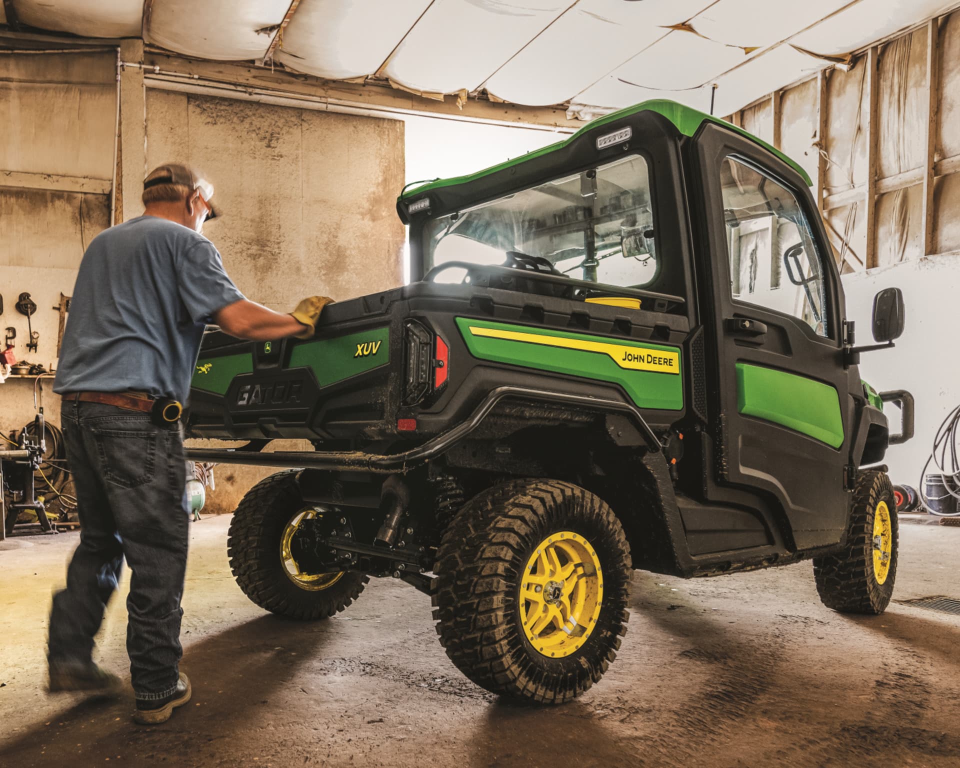 A man closes the tailgate of his John Deere Gator.