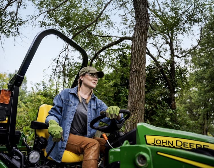 A property owner operates a John Deere 1025R on their land.