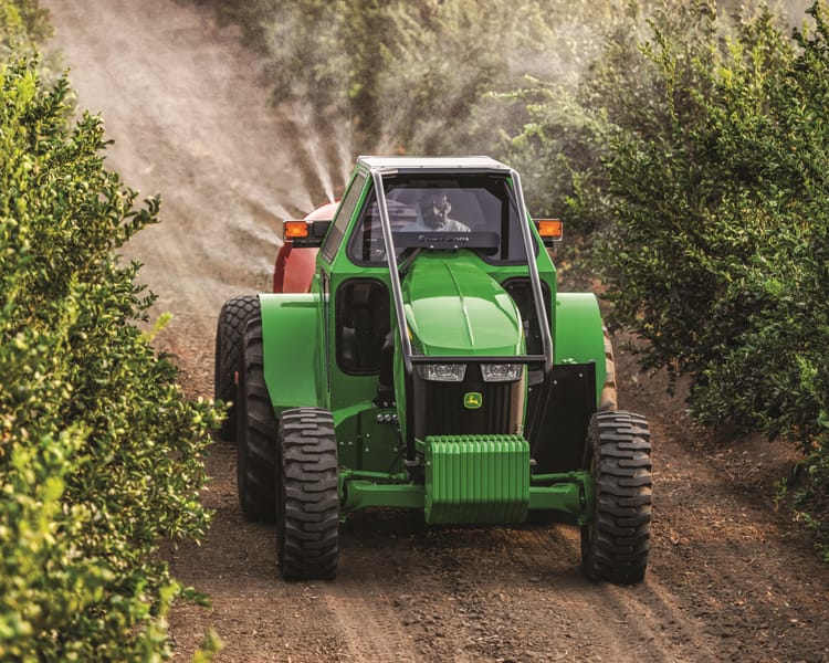 A specialty orchard tractor sprays crops on a vineyard in California.