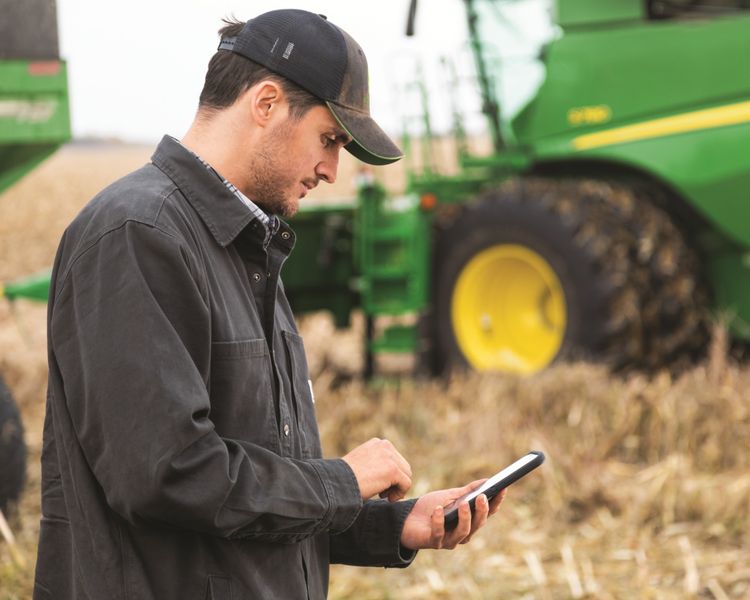 A farmer uses the Equipment Mobile App to manager their fleet.