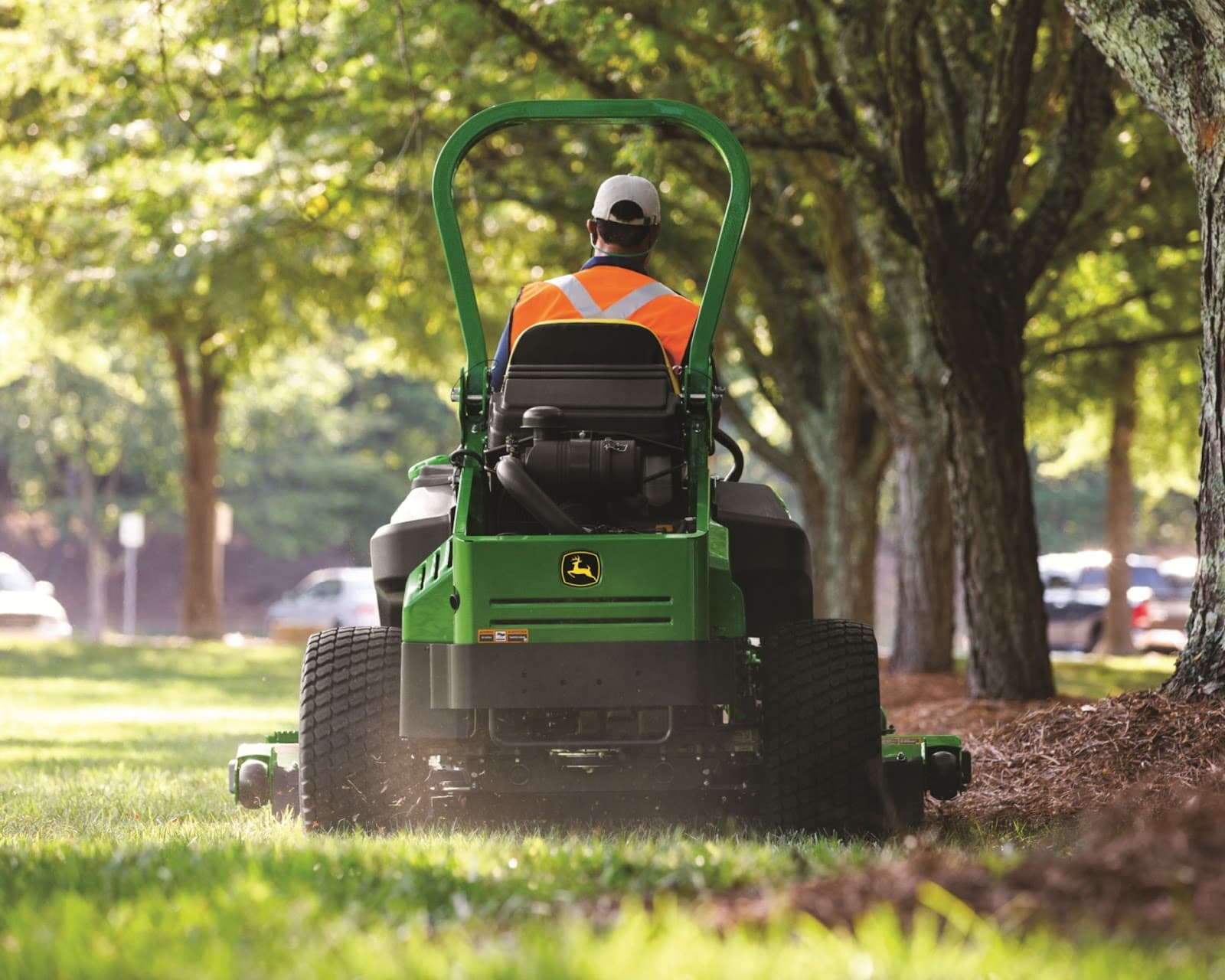 A behind view of a worker operating a John Deere Z994R mower.