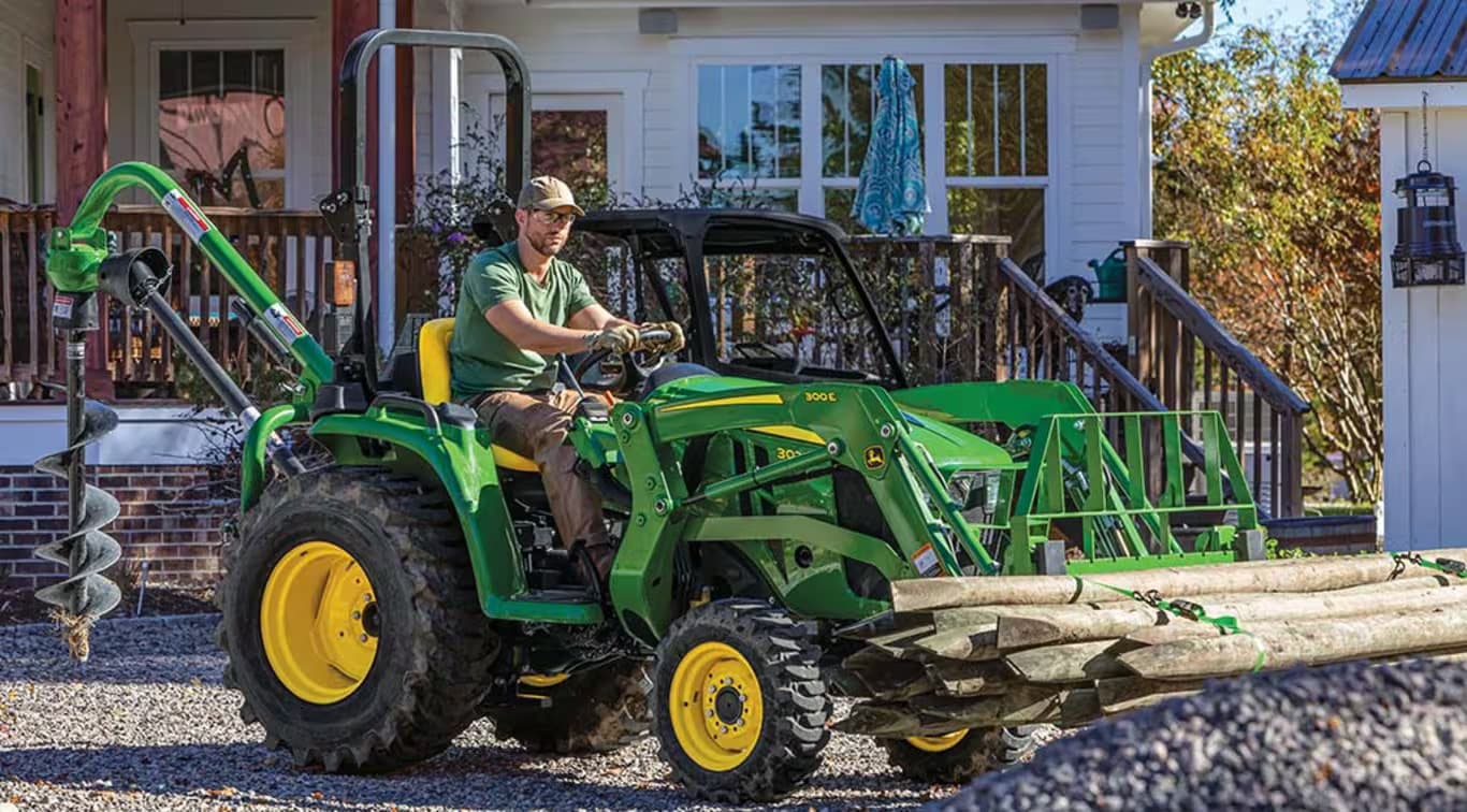 A property owner transports wood with a John Deere 3025E and a front-end loader.